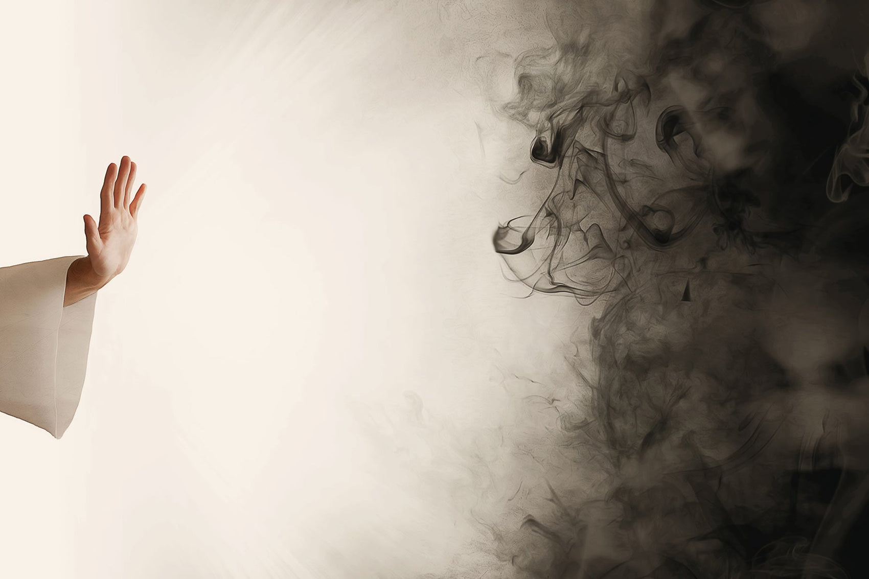 The hand of a Buddhst monk pushing away black smoke (negativity or insults.)