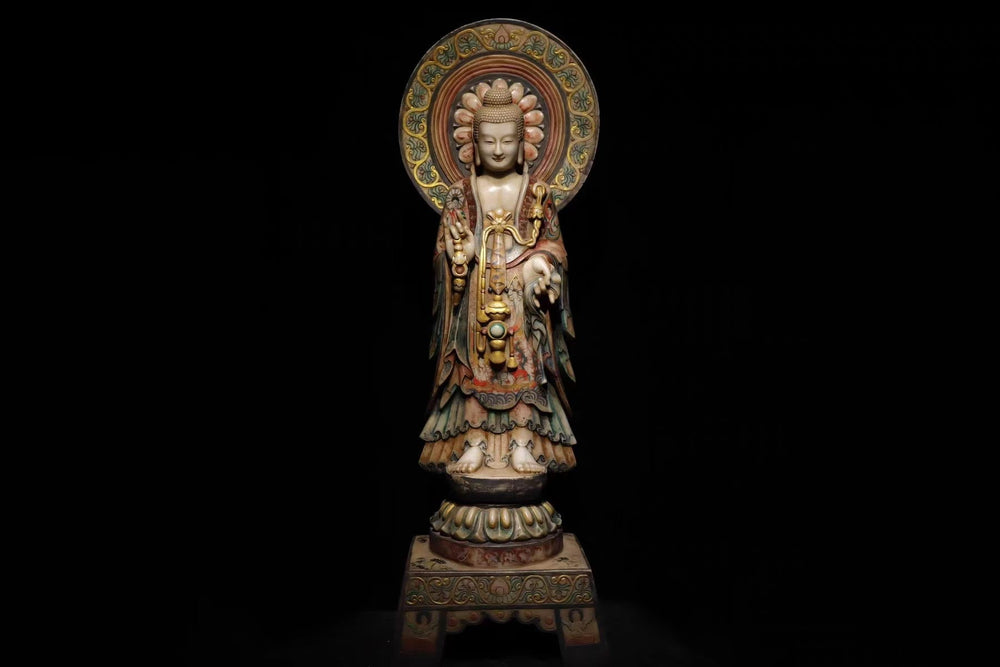 A full-body view of an ornate Kuan Yin statue with intricate robes and a detailed halo. She's standing in a gesture of compassion against a black background. This statue symbolizes serenity, wisdom, and spiritual presence.